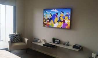 TV installation design ideas with floating shelves mounted below.